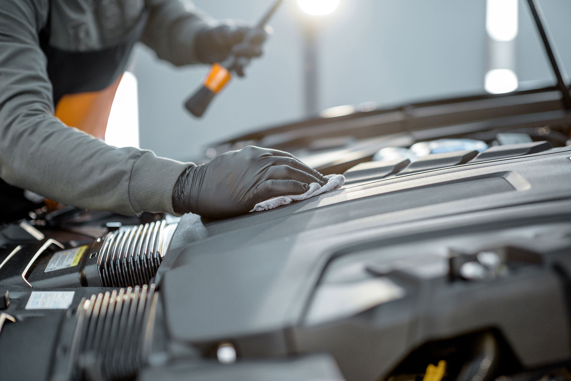 Mechanic in black glove fixing car engine.