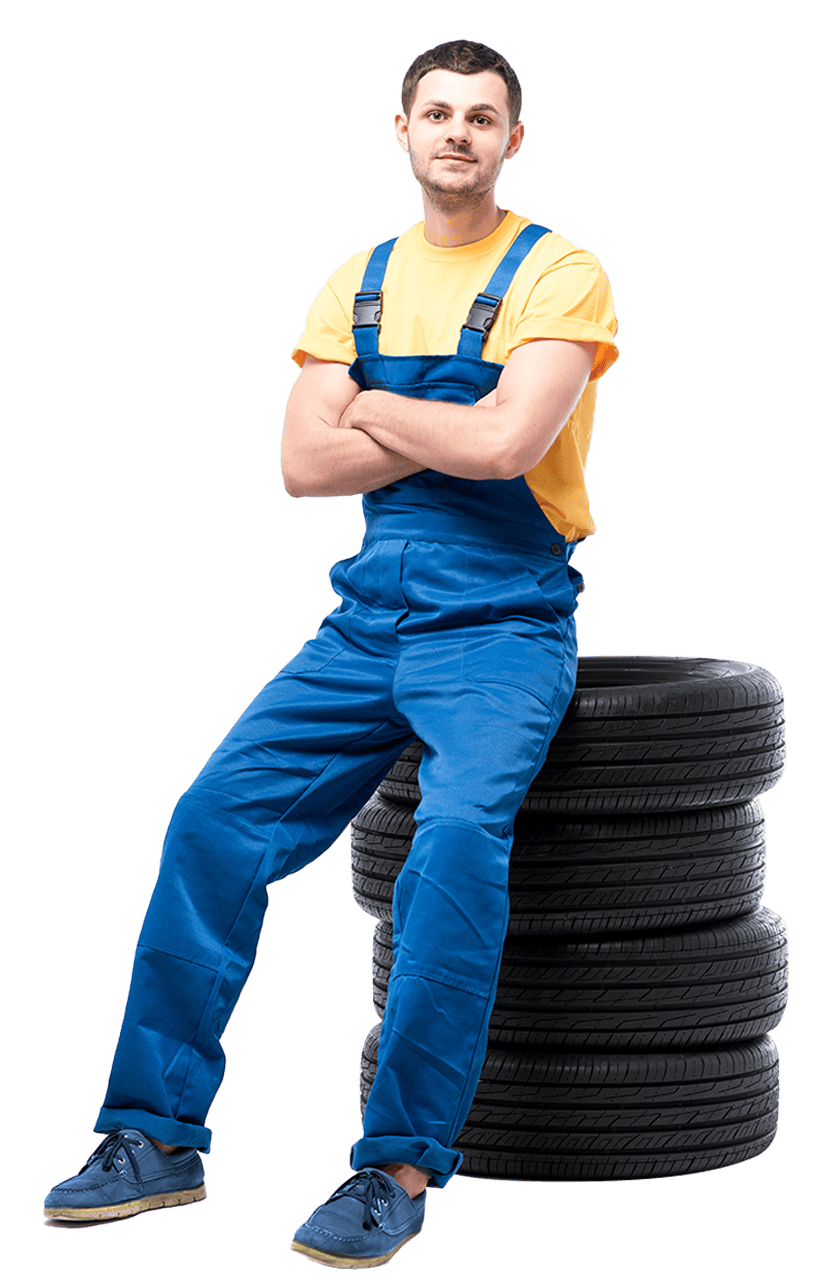 Man sitting on stack of tires, looking contemplative.
